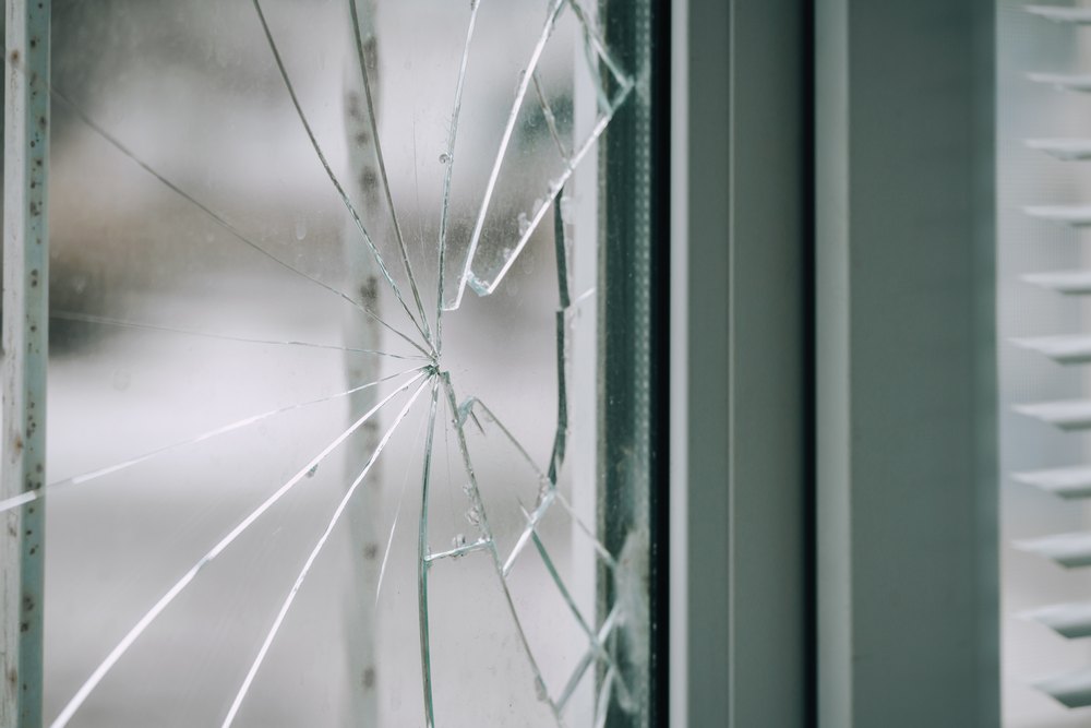 Glass,Broken,By,Hooligans,In,A,Metal-plastic,Window,,Close-up.